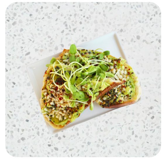 Avocado toast topped with seeds and sprouts on sourdough